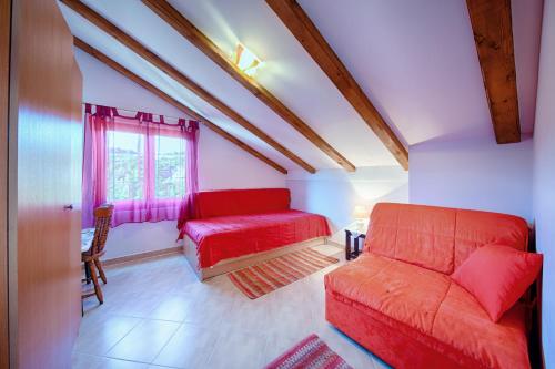 a living room with a red couch and a window at Apartments Pol Murvu in Vis