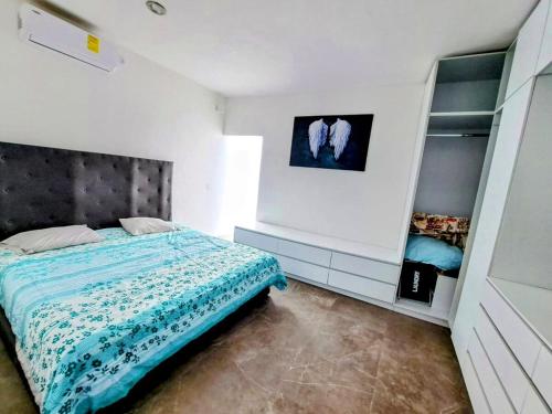 a bedroom with a bed with a blue blanket at Private house with two pools for up to 25 people in Atlacholoaya