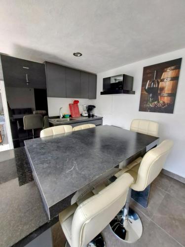 a kitchen with a large black table and chairs at Private house with two pools for up to 25 people in Atlacholoaya