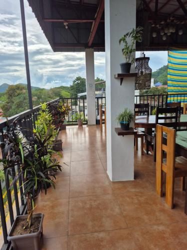 a balcony with a table and chairs and plants at Alec Lodge in Coron