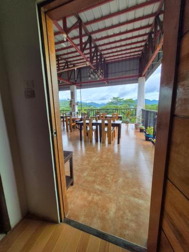 a room with tables and chairs and a glass door at Alec Lodge in Coron