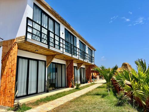 a building with black and white windows and palm trees at Casa Eyzaguirre - Zorritos in Bocapán