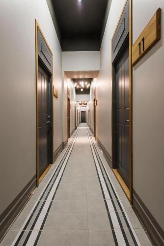 a long hallway with black doors and tile floors at Stylish Apartment near Old Town in Tallinn