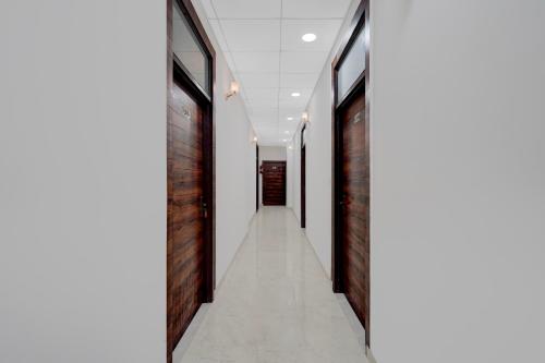 a hallway with red brick walls and a white floor at Hotel O THE GOMTI GLITZ in Gomti Nagar