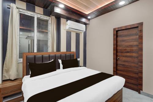 a bedroom with a large bed and a window at Hotel O THE GOMTI GLITZ in Gomti Nagar