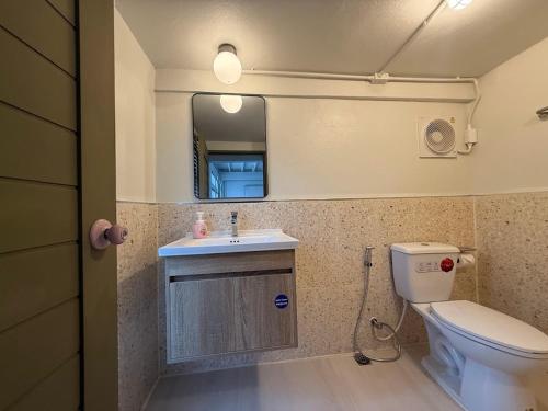 a bathroom with a toilet and a sink and a mirror at City Center, Private Cozy house at Night Bazaar in Chiang Rai