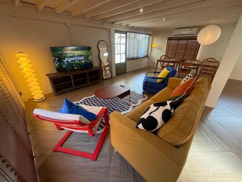 a living room with a couch and a tv at City Center, Private Cozy house at Night Bazaar in Chiang Rai