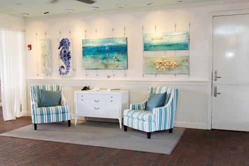 two chairs and a desk in a room with paintings at WaterColor Inn & Resort in Santa Rosa Beach