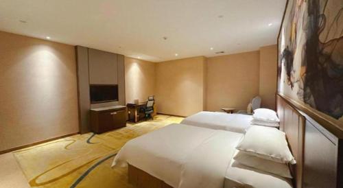 a hotel room with a bed and a television at Venus Royal Hotel Nanning East High-Speed Railway Station in Nanning