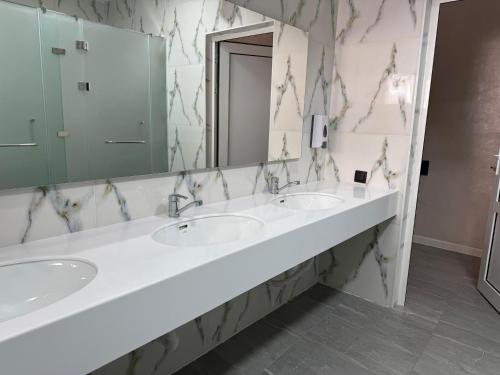 a bathroom with two sinks and a large mirror at Khan Hostel in Shymkent