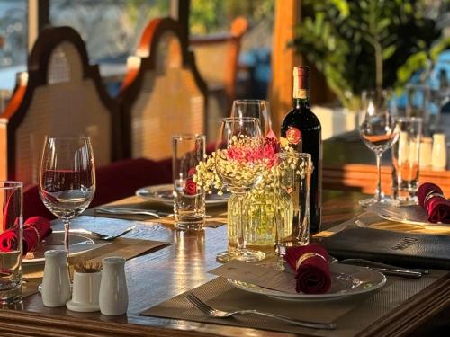 a wooden table with glasses and a bottle of wine at Verdure Lotus Grandeur Cruise on Ha Long Bay in Ha Long