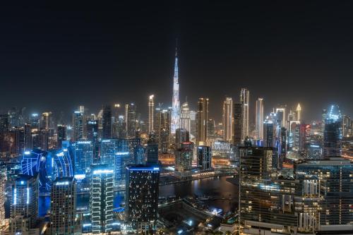 a night view of a large city with lights at Samaya Holiday Homes - Nobles Family Modern Suites in Dubai
