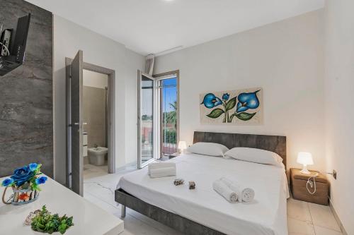 トッレ・ラピッロにあるPino Resort with shared poolの大きなベッドとバスルームを備えた白い寝室