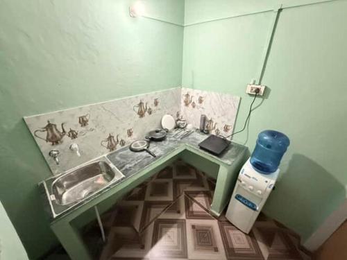 Kashi dham Homestay ( close to Kashi Vishwanath temple and Ghats) في فاراناسي: حمام صغير مع حوض وموقد