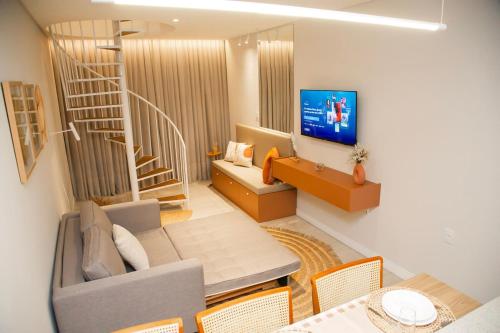 a living room with a couch and a staircase at Moderno Loft Urban Beach em Itajai - SC -Praia do Atalaia in Itajaí