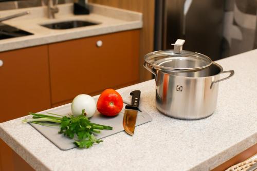 a cutting board with vegetables and a pot on a counter at Moderno Loft Urban Beach em Itajai - SC -Praia do Atalaia in Itajaí