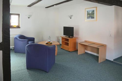 a living room with two chairs and a tv and a table at Doernersches Haus in Walldorf