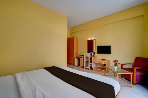 a hotel room with a bed and a television at Hotel O ALT pods in Bengaluru