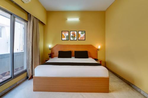 a bedroom with a bed and a large window at Hotel O ALT pods in Bengaluru