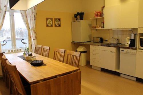 a kitchen with a wooden table and chairs and a counter at Stationshusets Hotell och Café in Köping