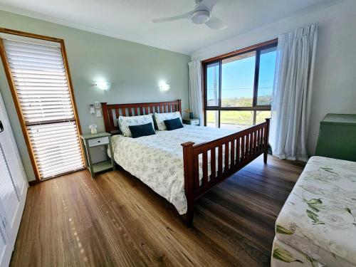 una camera da letto con un letto e una grande finestra di Large Private Apartment beach sunrise park views a Urangan