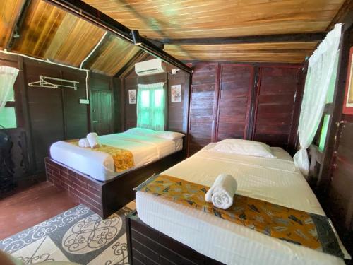 a bedroom with two beds in a room at Cenanghill Beachfront in Pantai Cenang