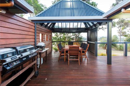 a wooden deck with a grill and a table and chairs at Roo-topia at Chez Nous - A Yallingup Sanctuary in Yallingup