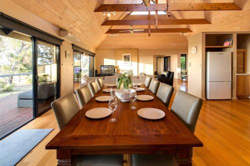 a dining room with a wooden table and chairs at Roo-topia at Chez Nous - A Yallingup Sanctuary in Yallingup