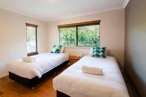 two beds in a room with two windows at Roo-topia at Chez Nous - A Yallingup Sanctuary in Yallingup