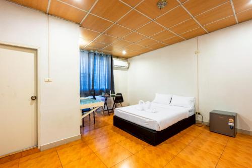a bedroom with a bed and a table in a room at At Gate Suvarnabhumi Airport - แอท เกท สุวรรณภูมิ in Ban Khlong Prawet