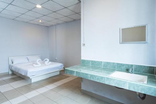 a bathroom with a sink and a bed in it at At Gate Suvarnabhumi Airport - แอท เกท สุวรรณภูมิ in Ban Khlong Prawet