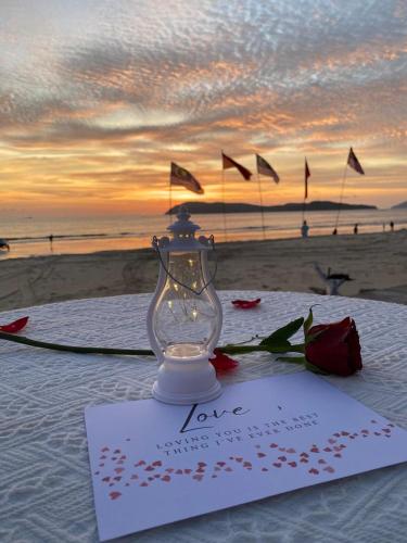 a table with a love card and a lantern on the beach at Cenanghill Beachfront in Pantai Cenang