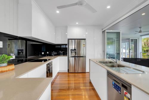 a kitchen with white counters and stainless steel appliances at 'Perfect Pool House' Idyllic Tropical Retreat in Edge Hill