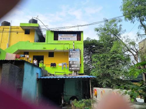 a yellow and green building with a sign on it at Sri Kanna Lodge CMC Vellore in Vellore