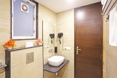 a bathroom with a toilet and a sink and a shower at Hotel Mayfair Just a Minute Away From New Delhi Railway Station and Connaught place in New Delhi