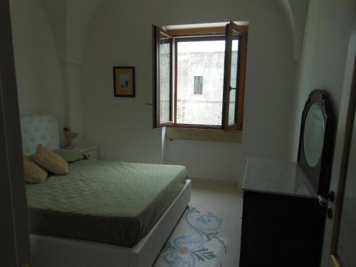 1 dormitorio con cama, espejo y ventana en Ciddini, en Andrano