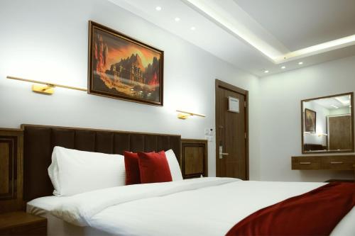 a bedroom with a bed with white sheets and red pillows at Petra Bermudez Hotel in Wadi Musa