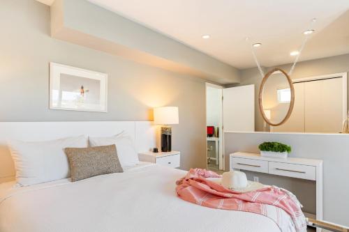 a bedroom with a white bed and a mirror at The Cayucan Bungalows by AvantStay Pet-Friendly Getaway Steps from Cayucos State Beach in Cayucos
