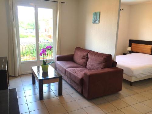 a living room with a couch and a bed at Résid'Artel Cadarache - ITER in Saint-Paul-lez-Durance