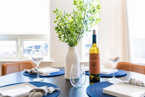 a table with a bottle of wine and a vase at The Cayucan Bungalows by AvantStay Pet-Friendly Getaway Steps from Cayucos State Beach in Cayucos