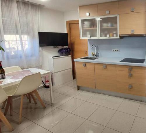 eine Küche mit einem Tisch und eine Küche mit einem Kühlschrank in der Unterkunft Aitetxe II Laguardia in Laguardia