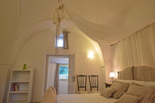 a bedroom with a white bed with a ceiling at Masseria Pagliamonte Ortensia in San Vito dei Normanni