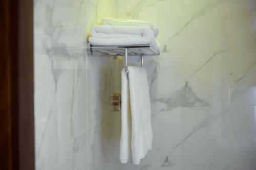 a bathroom with white towels on a towel rack at Petra Bermudez Hotel in Wadi Musa
