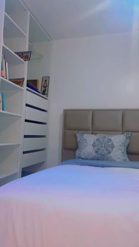 a bedroom with a white bed and a book shelf at Coumbis Faye in Brussels