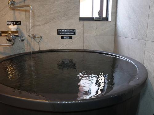 a bath tub in a bathroom with a shower at TOTONOU Awajishima in Awaji