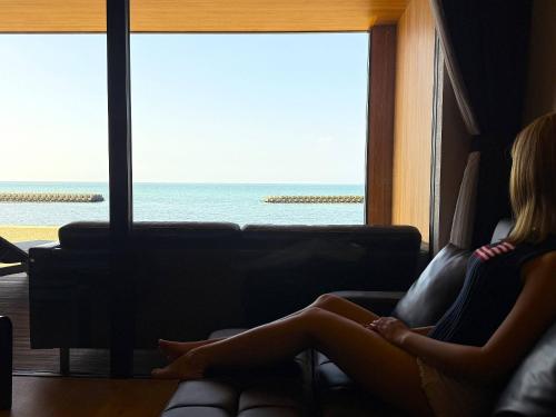 two women sitting on a couch looking at the ocean at TOTONOU Awajishima in Awaji
