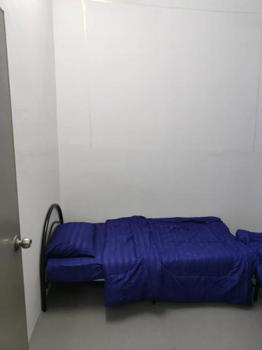 a blue bed in a room with a door at Homestay Kg Razali in Kuantan