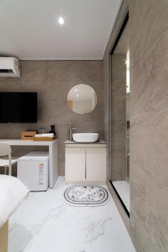 a bathroom with a sink and a television in a room at The Central Hongdae in Seoul