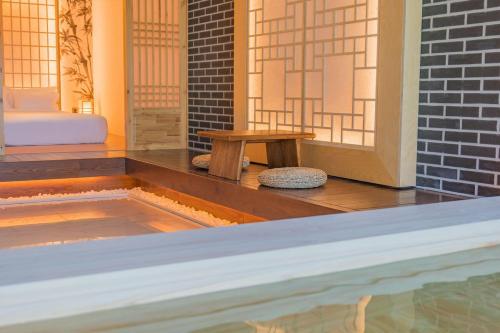a pool with a table and a bench in a room at Yeonhwamoon Hotel Byeonsan in Buan