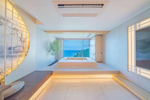 a bathroom with a tub in a room with a window at Yeonhwamoon Hotel Byeonsan in Buan